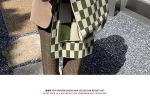 Close-up of green and white checkerboard knit scarf with soft wool texture for winter
