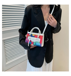 Detail of colorful geometric block mini bag with white handle and silver metal hardware