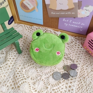 Mini plush frog coin purse with metal chain on lace cloth showing soft texture