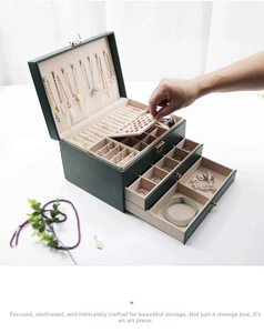 Detail of dark green jewelry box showing three-layer storage layout and metal lock