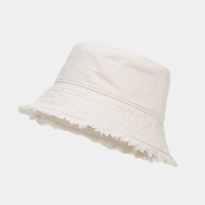 Close-up of beige canvas bucket hat with frayed edge detailing and minimalist retro design