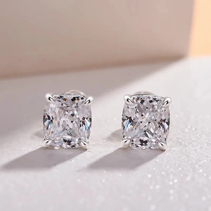Macro shot of cushion-cut zircon stud earrings with classic four-prong silver setting