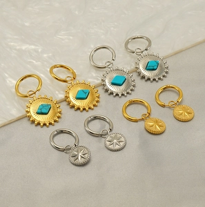 Detail of vintage sun flower and starburst earrings with turquoise in gold and silver