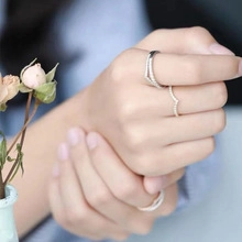 Close-up of a silver turtle-themed jewelry ring set with zircons on a woman's hand