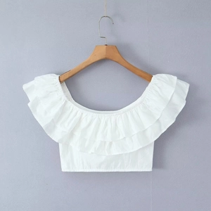 Detail of white off-the-shoulder crop top with tiered ruffle neckline on a wooden hanger