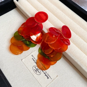 Macro detail of multi-layered translucent colorful resin disk tassel drop earrings