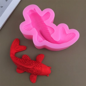 Pink silicone koi fish mold with a detailed red resin fish model on a grey background