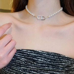 Gros plan d'un collier ras du cou en perles avec fermoir CD serti de strass sur modèle