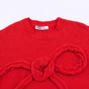 Red crew neck knit sweater featuring a large 3D knitted bow on the chest area