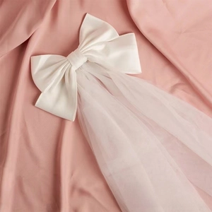 Elegant white double-layer bridal bow veil with satin bow and sheer tulle on pink silk
