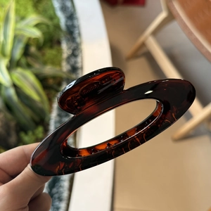 Details einer großen bernsteinfarbenen Haarklammer aus Acryl mit elegantem Aussparungsdesign