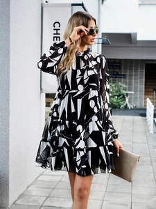Photo de rue d'une mini-robe à volants et manches longues à motif géométrique noir et blanc
