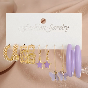 Detail of five-pair earring set with pearls and purple resin on a jewelry card
