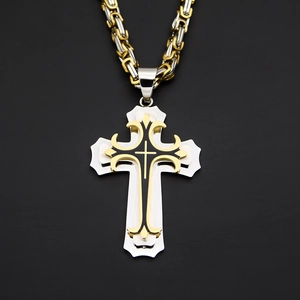 Macro shot of double-layer cross pendant with black enamel and two-tone Byzantine chain
