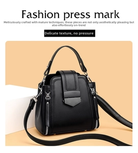 Detail of black stylish handbag showing refined stitching and metallic hardware buckle