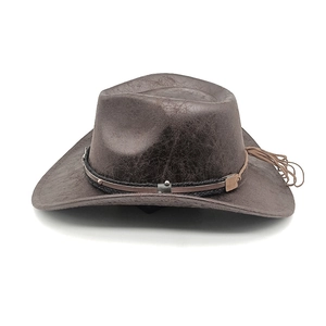 Detail of brown western cowboy hat with cracked leather texture and studded woven band