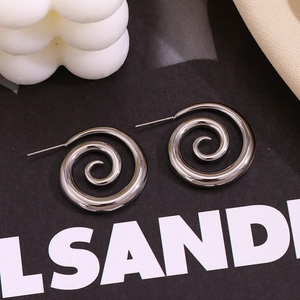Detail shot of silver spiral stud earrings with polished mirror finish on black card