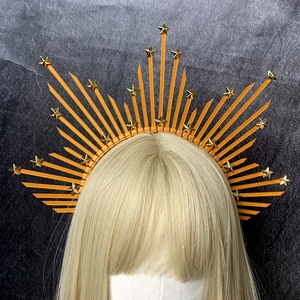 Close-up of golden star elements on an orange halo crown headpiece with spiked texture