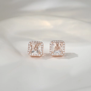 Macro detail of square princess cut stud earrings in rose gold with halo crystal setting