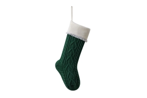Detail of forest green knit Christmas stocking with heart patterns and tassels