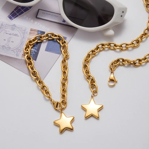 Detail of gold star pendant set with chunky chain necklace and matching bracelet
