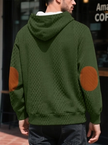 Détail du sweat à capuche en maille gaufrée vert foncé avec empiècements marron aux coudes