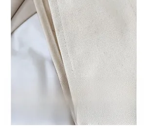 Macro shot of precise double-stitched seams on heavy-duty beige canvas tote bag