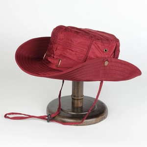 Detail of burgundy outdoor sun hat featuring metal vents and adjustable chin strap