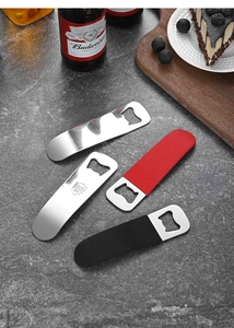 Detail of stainless steel bottle openers with PVC handles next to a beer bottle