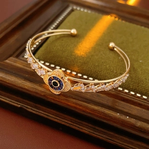 Dettaglio macro del bracciale dorato Evil Eye con zirconi brillanti e ciondolo occhio blu