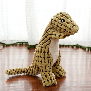 Detail of khaki corduroy dinosaur plush toy with textured fabric on wooden floor