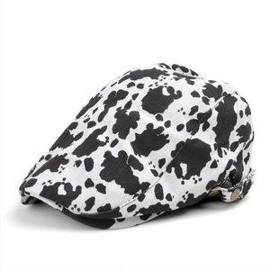 Vintage cow print newsboy cap with adjustable metal buckle and black and white pattern