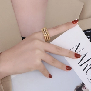 Detailed view of a gold-plated three-layer gear ring with pavé zircons on a model hand