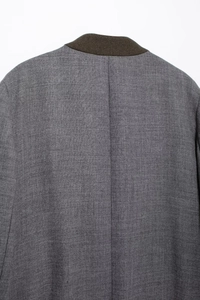 Detail shot of a gray wool blazer showing brown collar and back seam texture