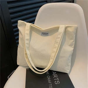 Minimalist cream corduroy tote bag displayed on chair with premium aesthetic style