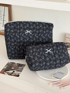 Detail of two-piece quilted floral makeup bags with white bows and zipper closure