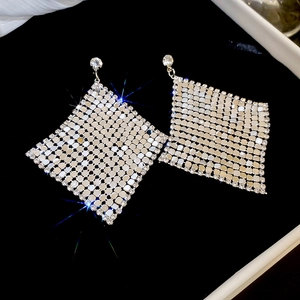 Detailed macro view of diamond-encrusted rhombic dangle earrings with sparkling mesh structure