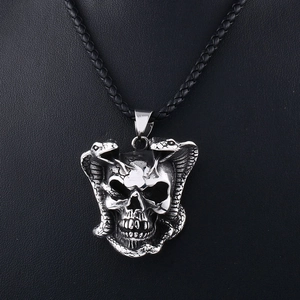 Detail von Punk-Totenkopf und Doppel-Schlange Anhänger an schwarzer Lederkordel