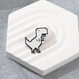 Minimalist pixel art chrome dino enamel pin on white geometric tray display