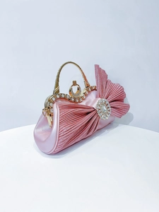 Detail view of pink satin evening bag with pleated design and rhinestone buckle