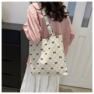 Détail du sac cabas en velours côtelé avec motifs nœuds noirs et surpiqûres en losanges