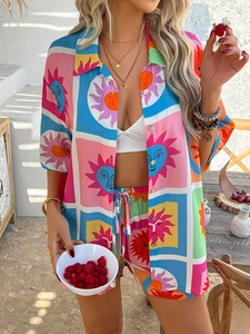 Detail of bohemian two-piece set with vibrant sun face print and shorts on a resort terrace
