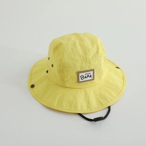 Detail of yellow quick-dry sun hat showing reinforced brim stitching and bear patch