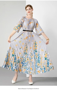 Detail van grijze geplooide midi-jurk met kleurrijke bloemenprints en een zwarte ceintuur