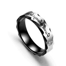 Detail of two-tone stainless steel ring featuring elvish script and a small crystal