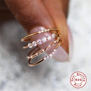 Macro detail of layered 925 sterling silver rings in rose gold with shimmering zircons