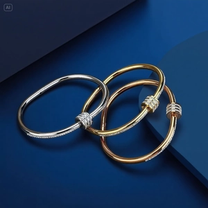 Titanium steel bangles in gold, silver and rose gold with diamond accents on blue background