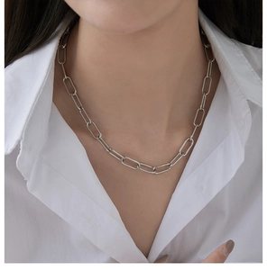 Silver paperclip chain necklace styled on a white shirt showing minimalist link detail