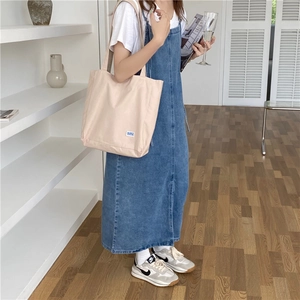 Bolso tote de lona a cuadros minimalista con un vestido vaquero casual en una escena real