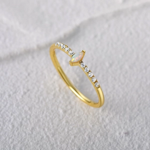 Macro detail of marquee opal engagement ring in gold with ten zircon accents
